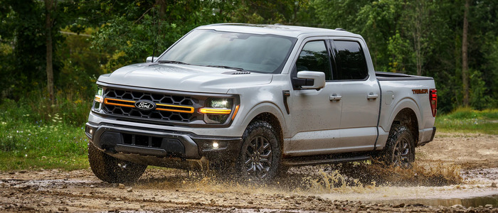 Gray Ford F-150 driving through the mud